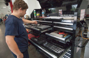 man selecting wrench from tool cabinet