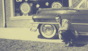 Young Man Kneeling Next to a 1950s Car