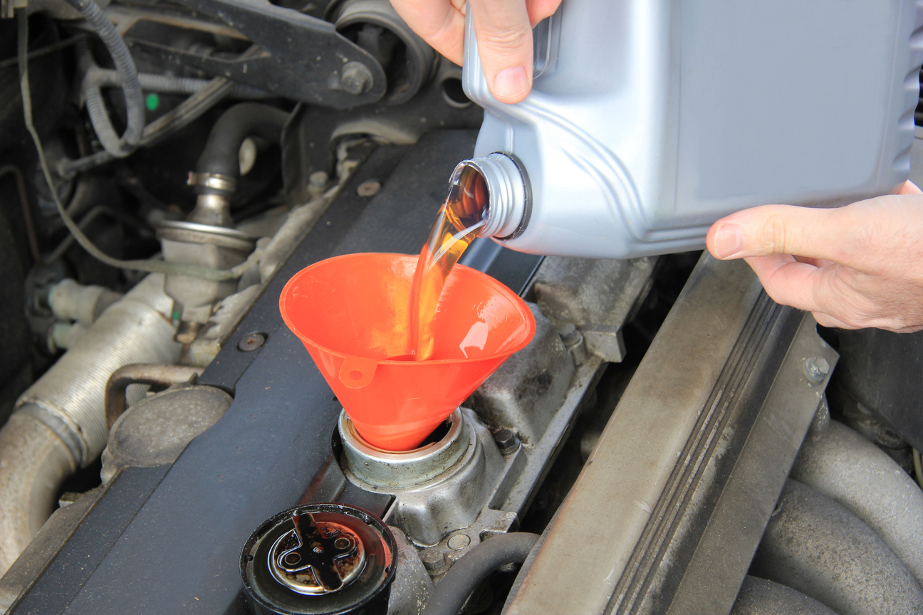 Man checking engine oil of an older car