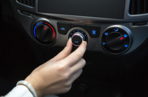 Woman turning on car air conditioning