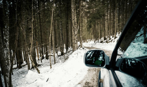 A car driving on a snow-covered road in the winter