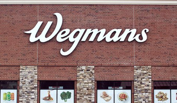Wegmans brick facade showing their sign and windows with colorful ads