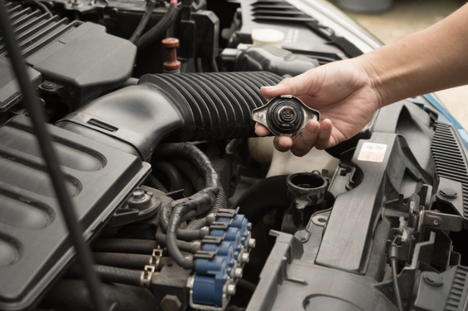 Mechanic holding the cap to a car's radiator