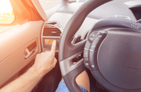 Person adjusting their car air conditioning