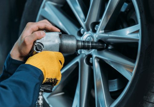 Mechanic changing a tire with a wheel lock key