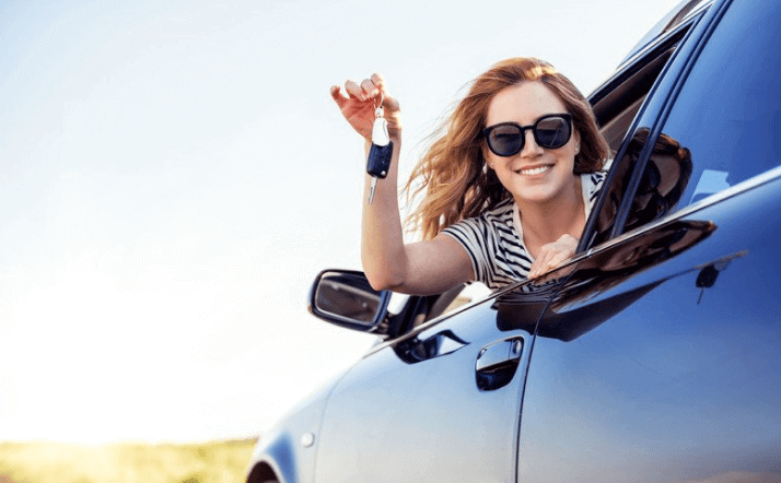 woman holding car keys out the window