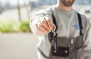 Mechanic extending a set of keys - pick-up and delivery mechanic service