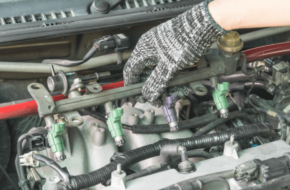 Picture of a fuel injector with a mechanic providing service