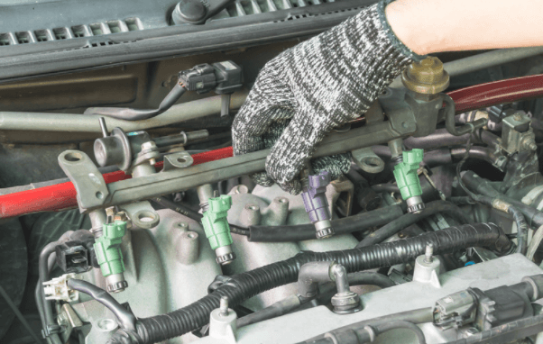 Picture of a fuel injector with a mechanic providing service