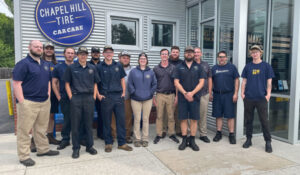 Chapel Hill Tire team standing in front of a shop and smiling for camera