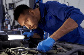 A mechanic looking at a car engine