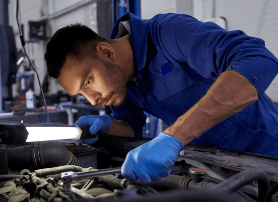A mechanic looking at a car engine