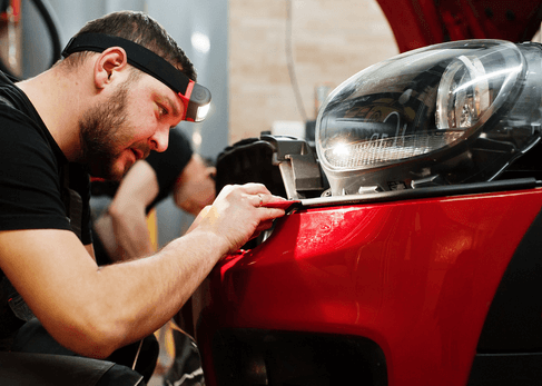 Repairman working on the bumper of a car