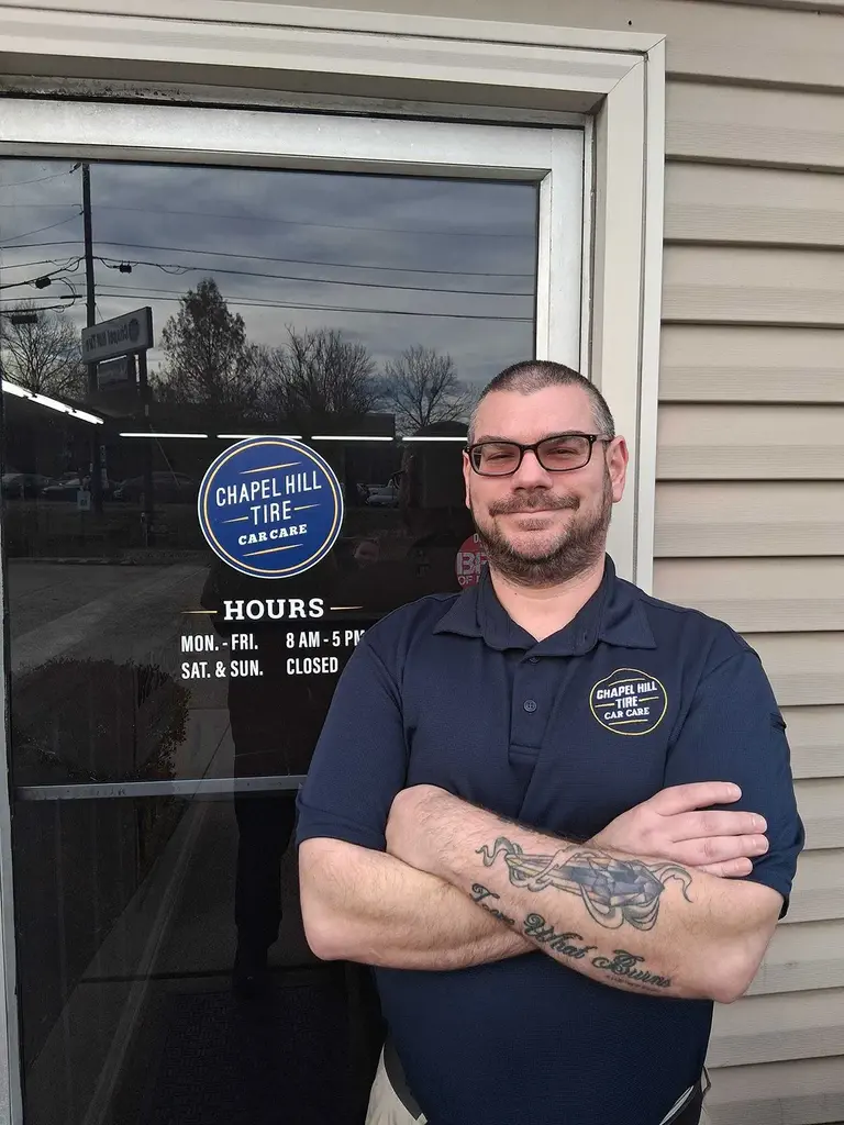 Chapel Hill Tire employee standing outside shop entrance