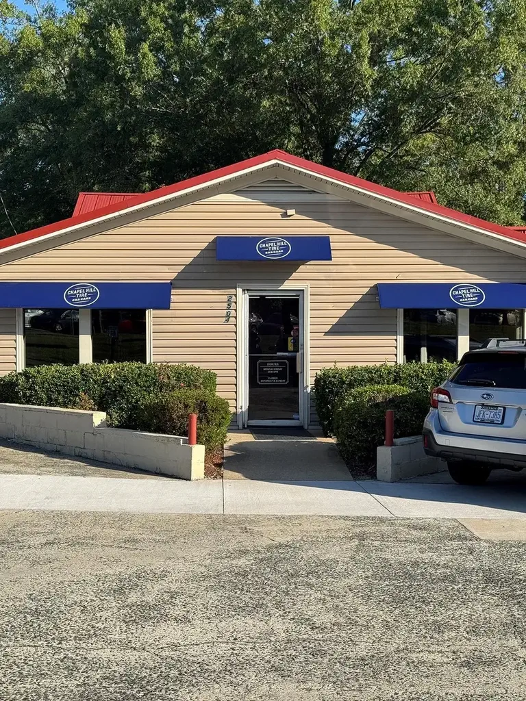 Chapel Hill Tire storefront with blue awnings and red roof