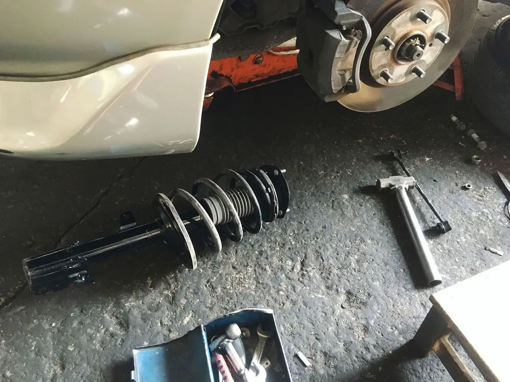 Car suspension repair with removed strut and tools