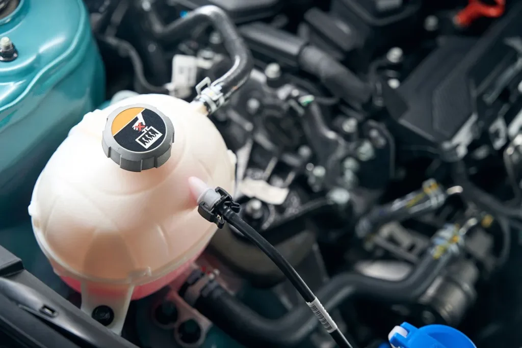 Car engine coolant reservoir with pink fluid