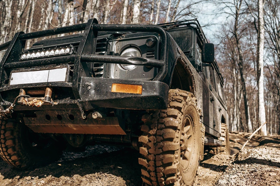Off-road SUV on muddy forest trail