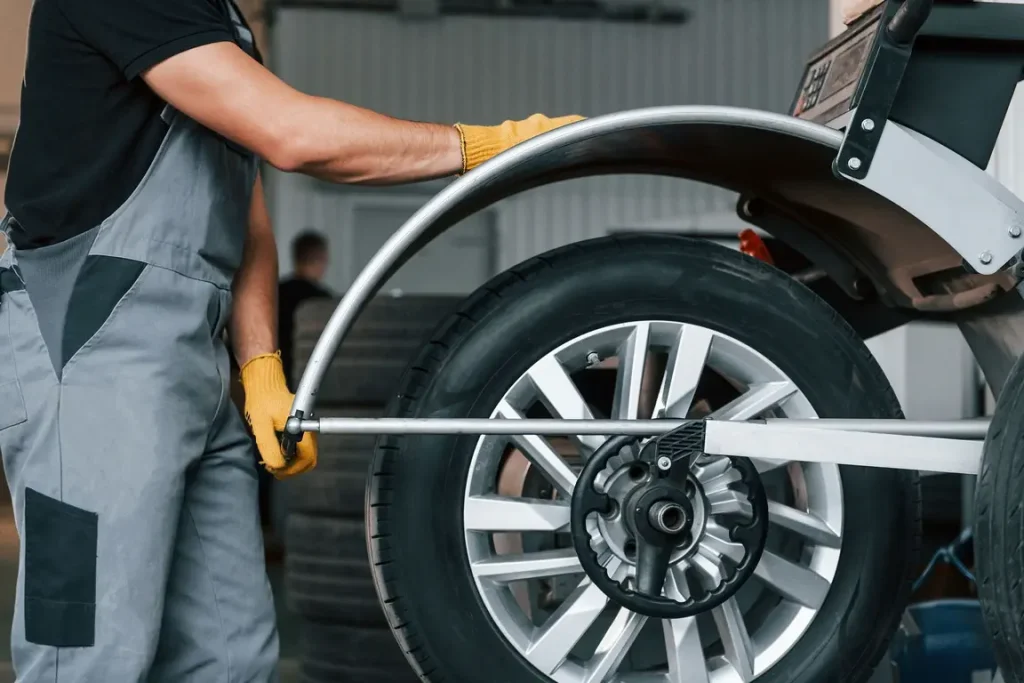 Mechanic balancing car wheel in auto shop