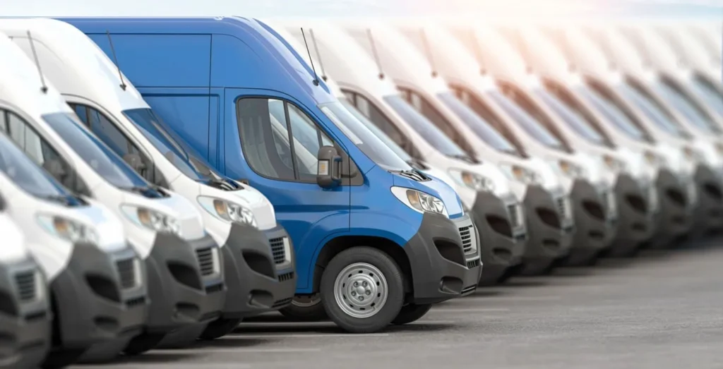 Blue delivery van parked among white fleet vans