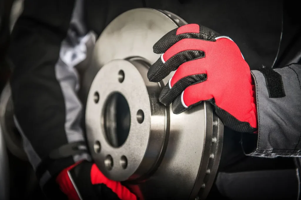 Mechanic holding a car brake disc rotor