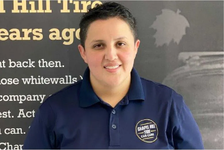 Smiling person wearing Chapa Hill Tire Car Care polo